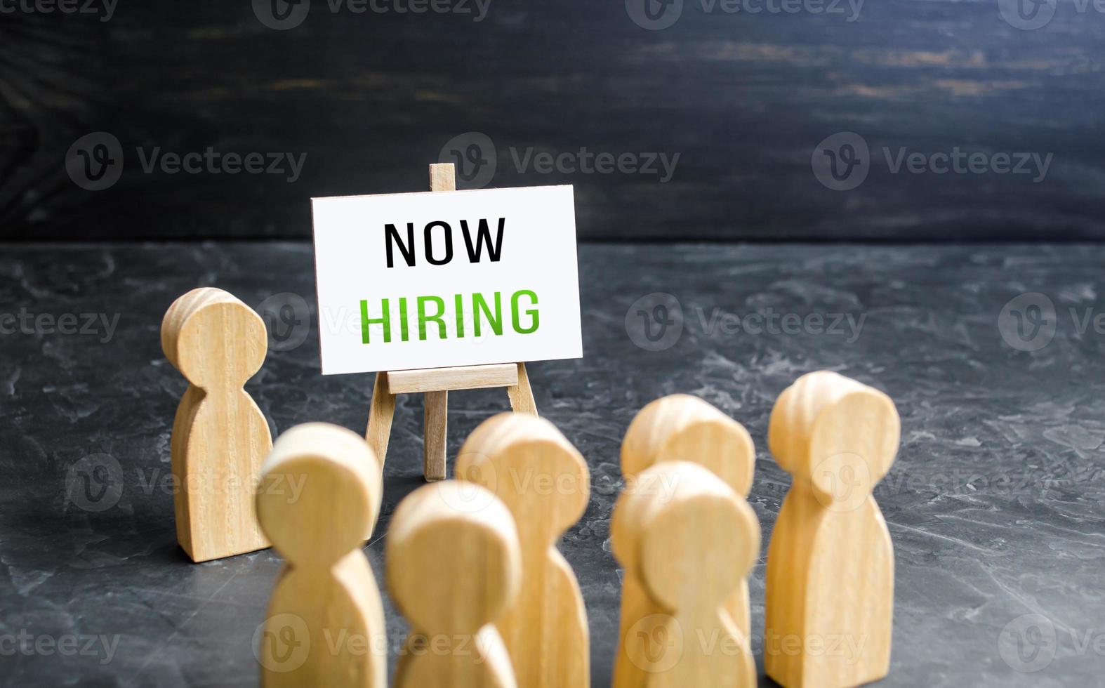 A man with a Now Hiring sign appeals to the crowd about hiring. Call for help, volunteering. Hire staff. Employment Agency. Recruiting, staffing. Search and recruitment of new employees for work. photo