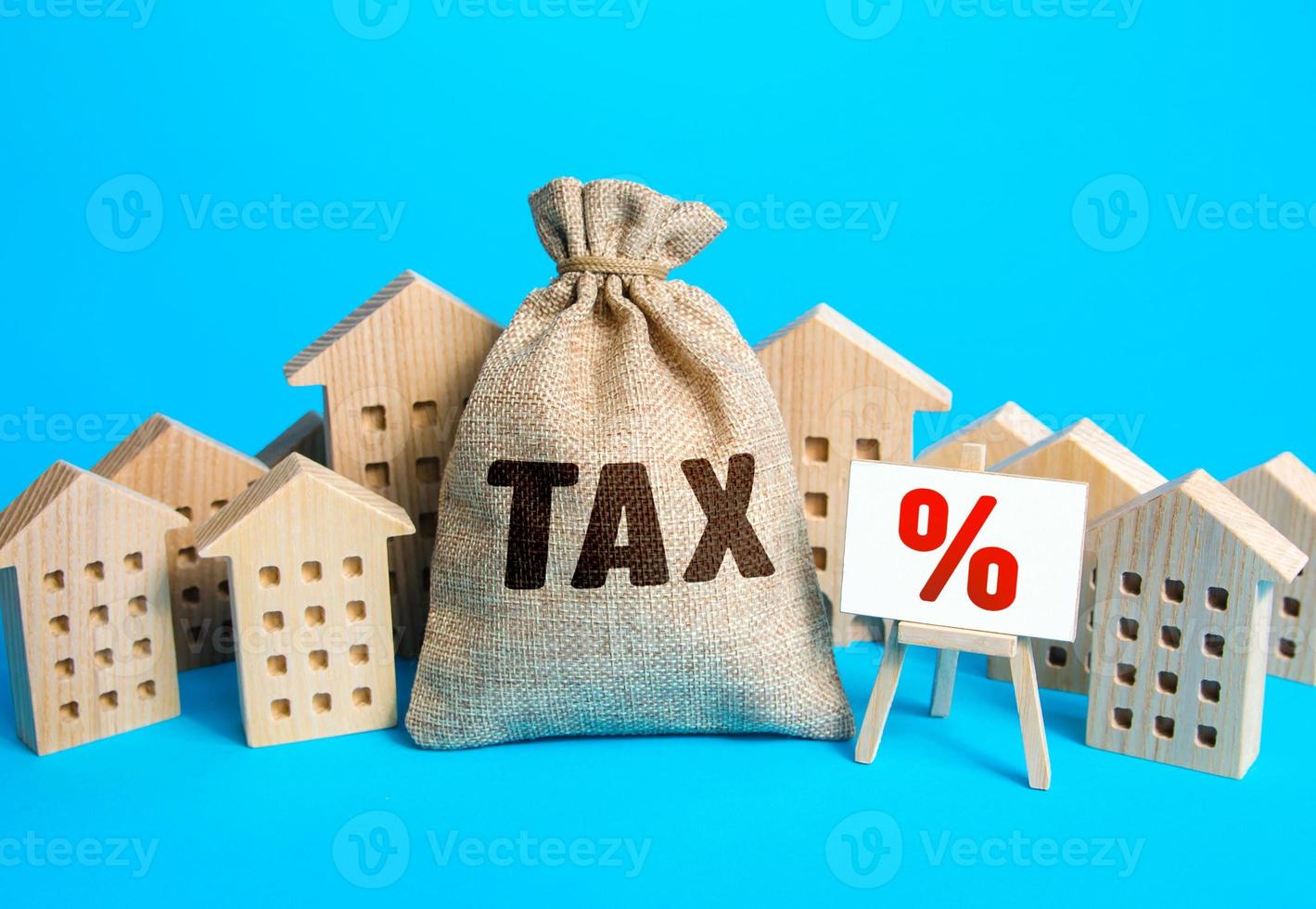 Houses and a bag of taxes. Real estate tax. Taxation on purchase or sale of a home. Maintenance of housing and land. Tax interest. Fees and duties. Rental business. Return on investment. Taxes relief photo