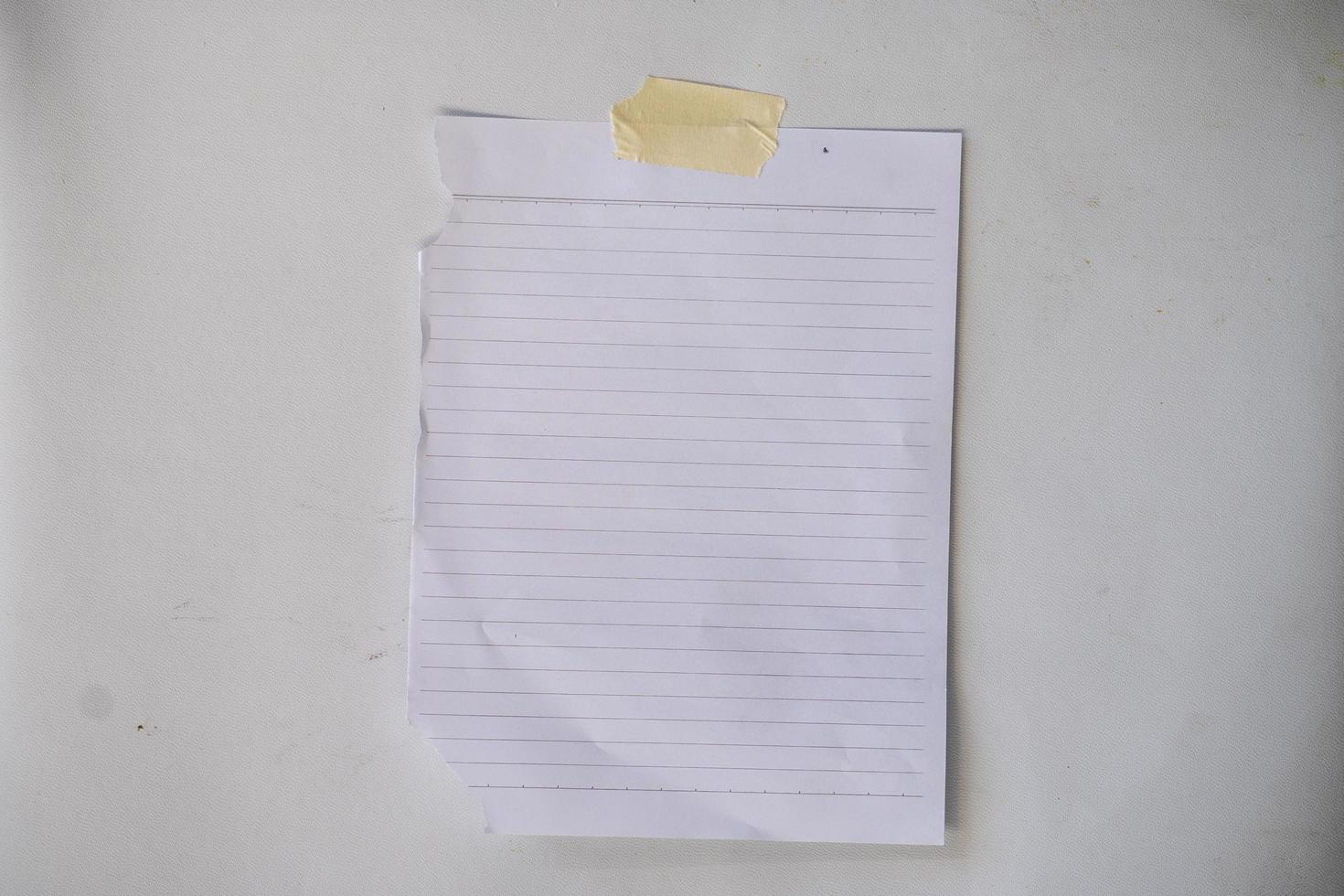 papel de nota adhesiva en blanco para maqueta. papel de línea de rayas pegado con cinta adhesiva en la pared foto