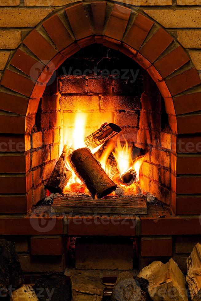 firewood and tongues of fire in fireplace photo