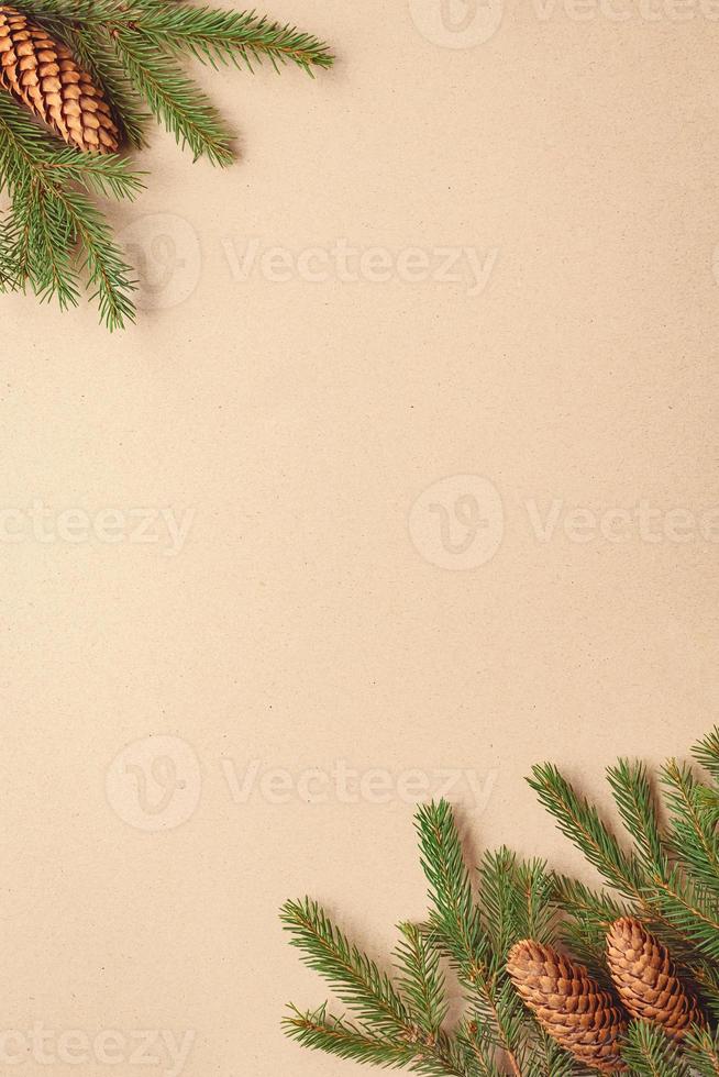 Christmas tree branches on brown paper background, spruce twigs and cones flat lay, copy space photo
