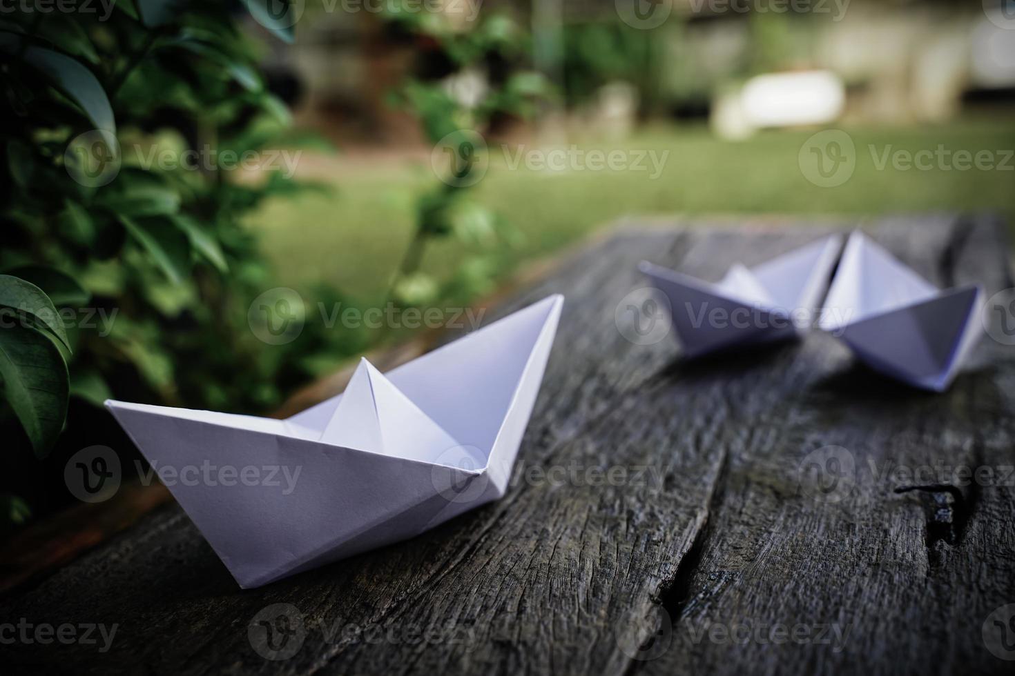 Origami, white paper boat isolated on a wooden floor. Paper boats mean walking. feeling of freedom leadership photo