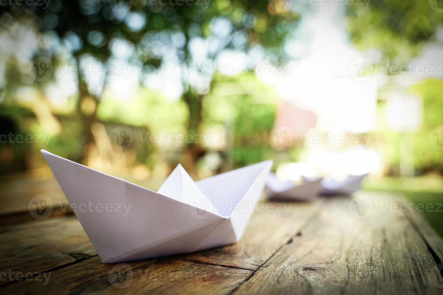 Origami, white paper boat isolated on a wooden floor. Paper boats mean walking. feeling of freedom leadership photo