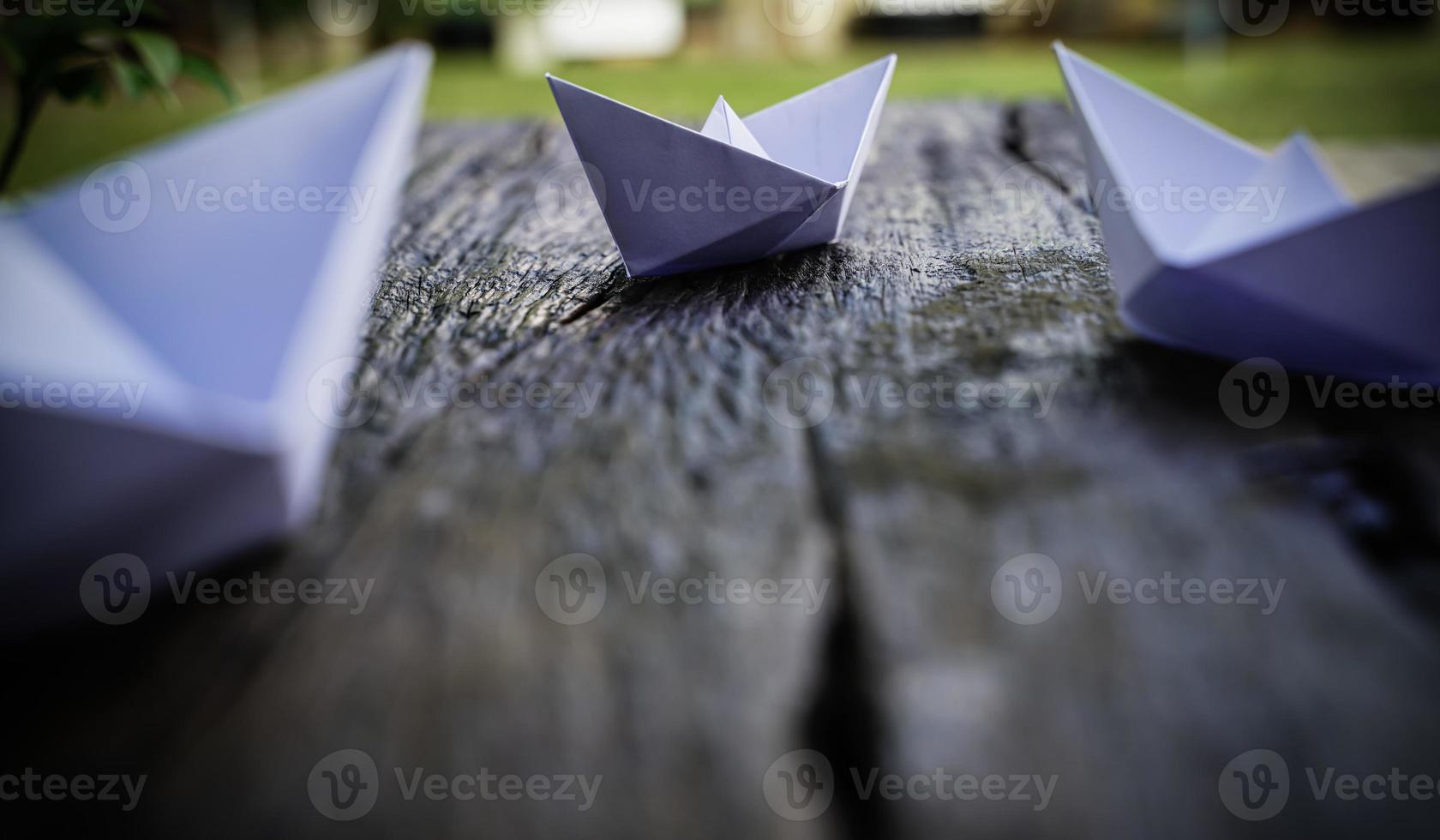 origami, barco de papel blanco aislado en un piso de madera. Los barcos de papel significan caminar. sentimiento de libertad liderazgo foto