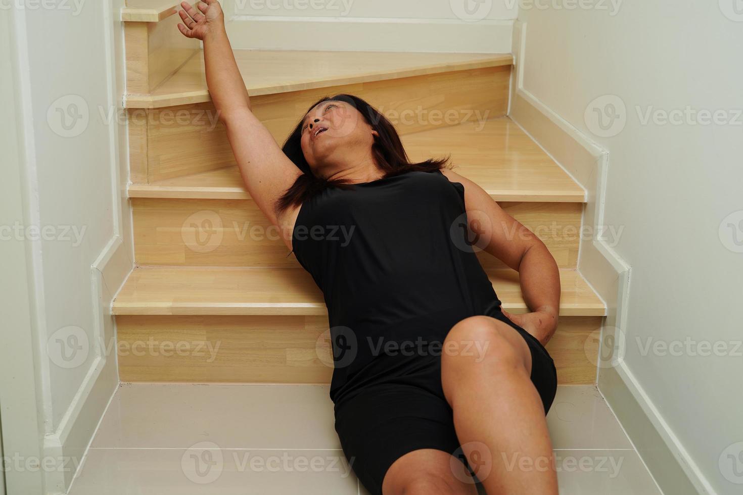 Asian lady woman injury from falling down on slippery surfaces stairs at home. photo