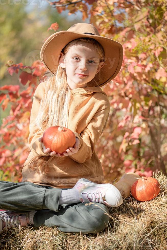 Girl in the hay with pumpkins photo