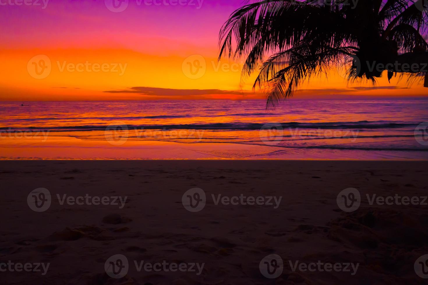 Silhouette of beautiful sunset on the sea beach with palm tree, sky on twilight time and reflection on the sea.for travel in holiday relax time, photo