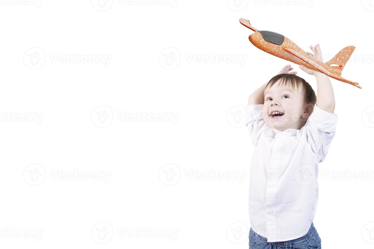 Kid with blond hair smiling and emotions on the face and raised hands with an airplane, two years old. White isolated background. photo