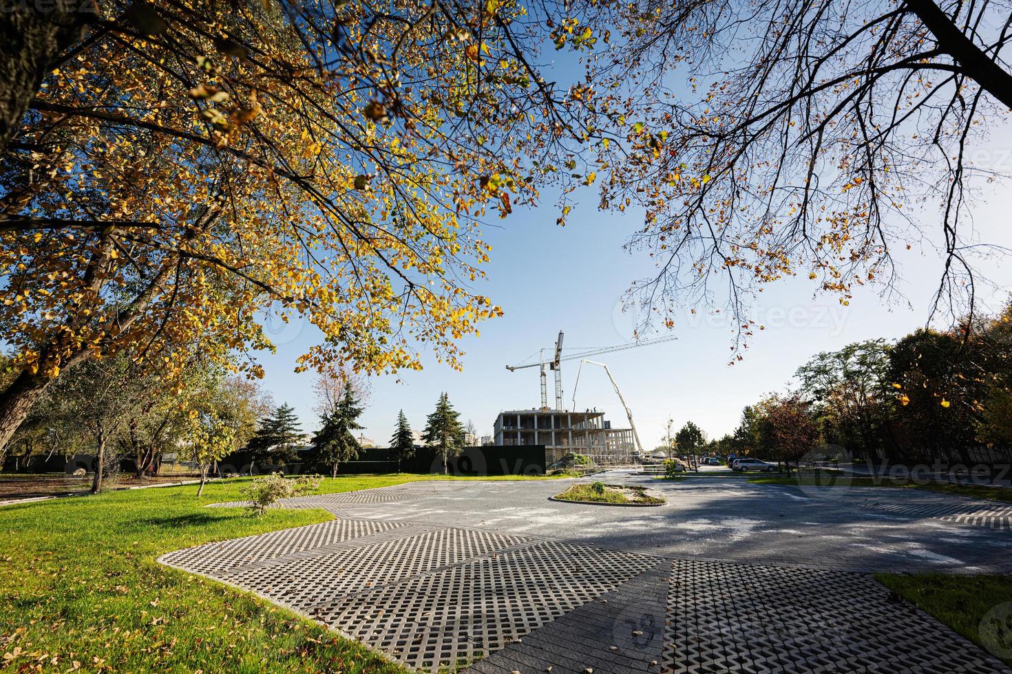 Construction of a new residential area of hig rise buildings near autumn city park. photo