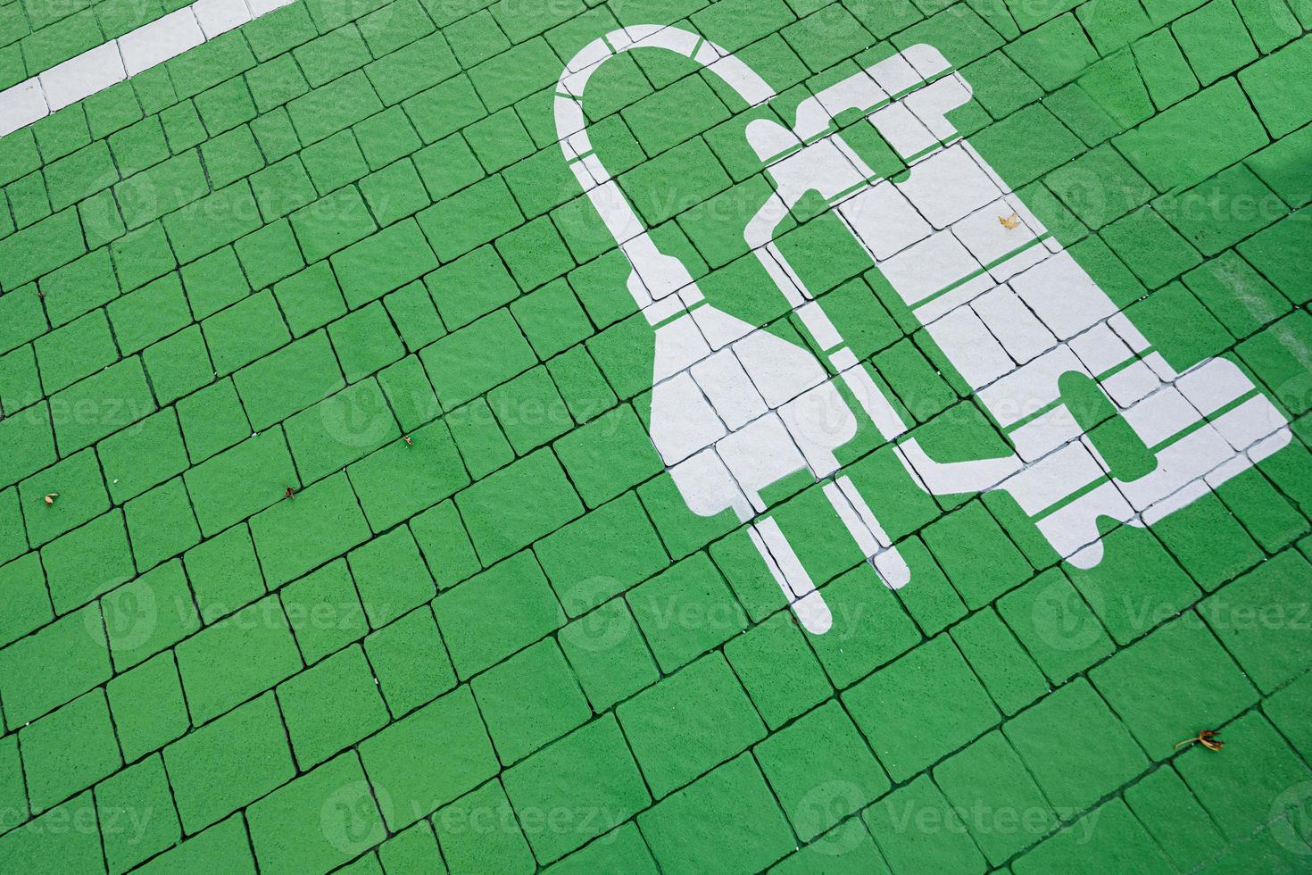 Green parking symbol for electric cars being charged in pavement. photo