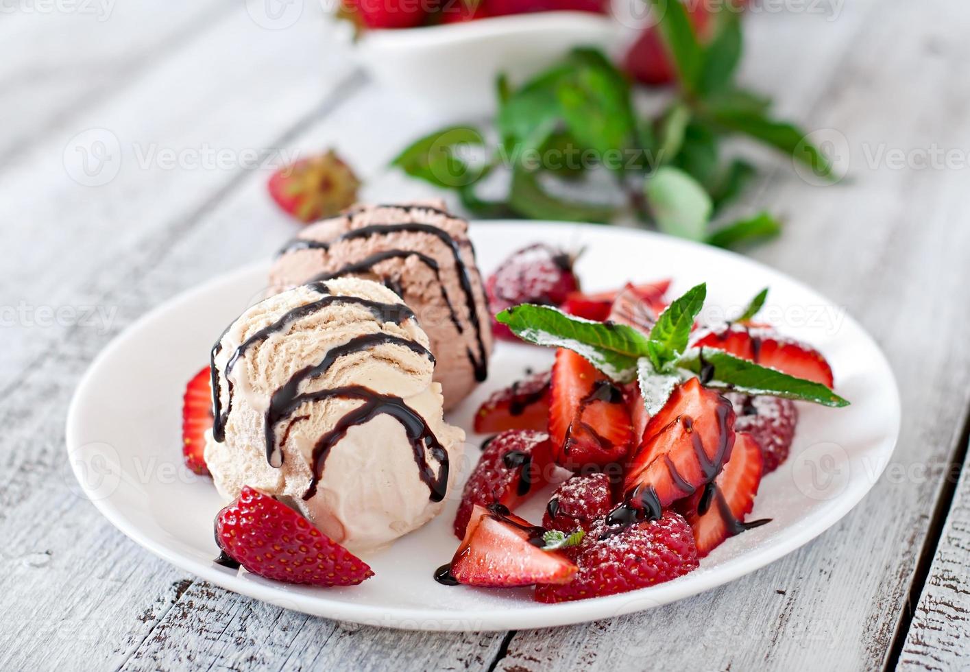 helado con fresas y chocolate en un plato blanco foto