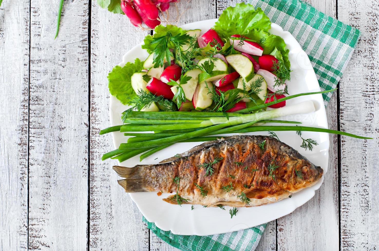 carpa de pescado frito y ensalada de verduras frescas foto