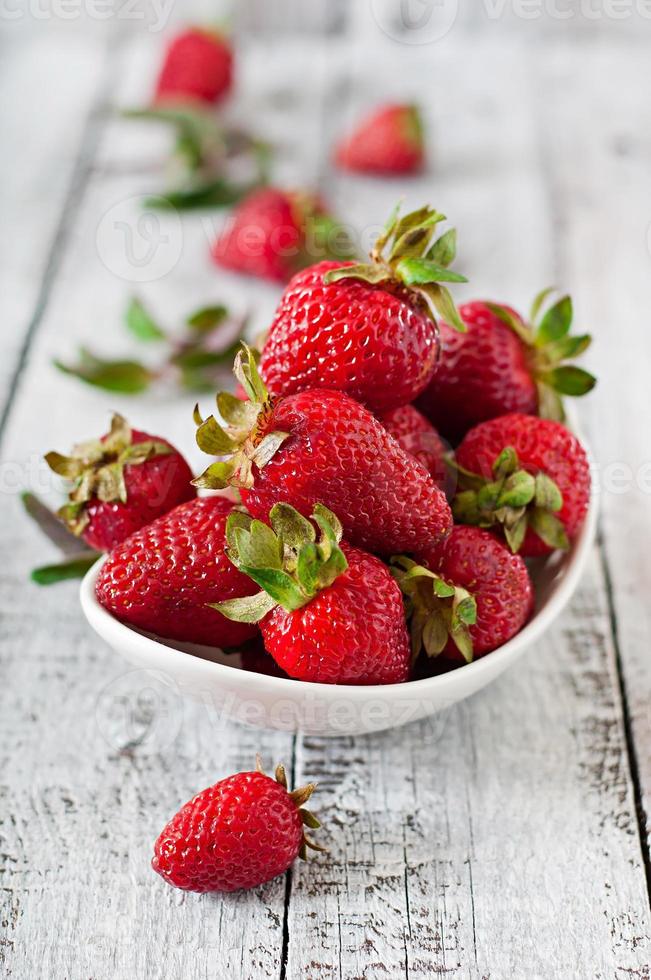 fresas frescas sobre un fondo de madera antiguo foto