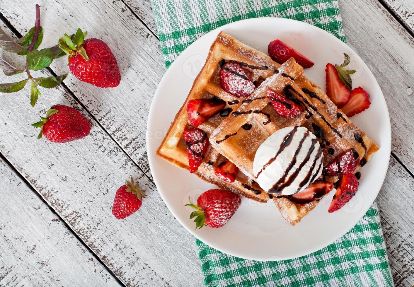 gofres belgas con fresas y helado en un plato blanco foto