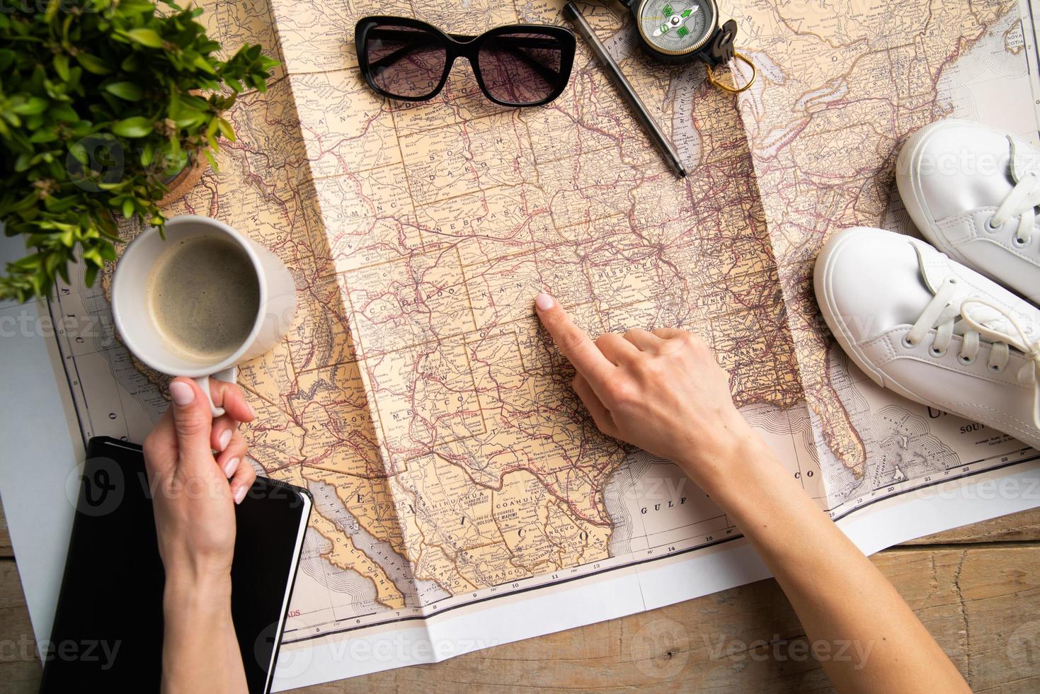 woman hand drawing on travel map, planning trip or vacation photo