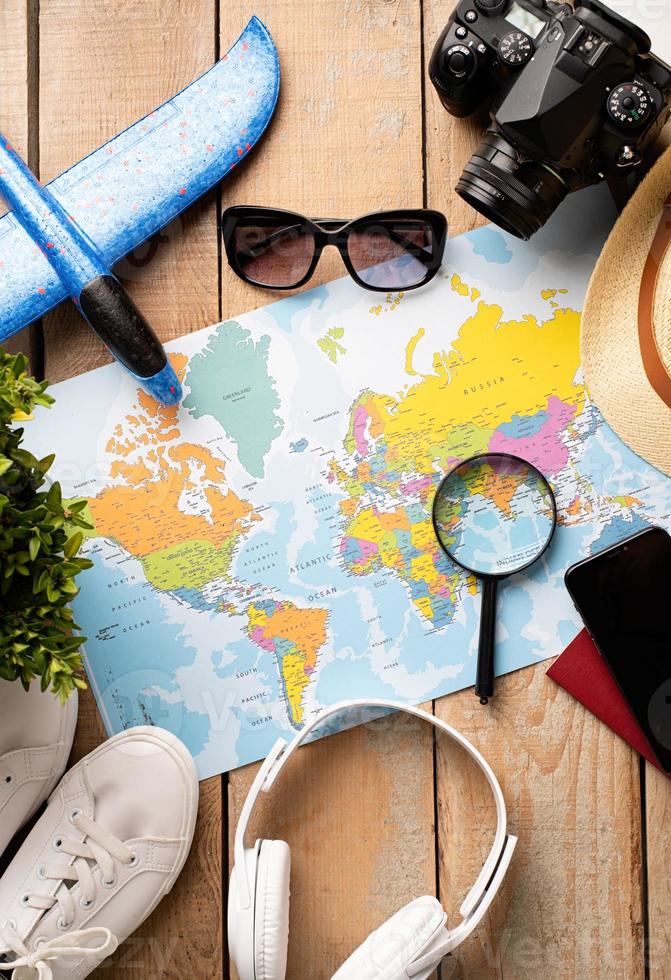 Flat lay traveler accessories on map, camera, glasses, digital devices photo