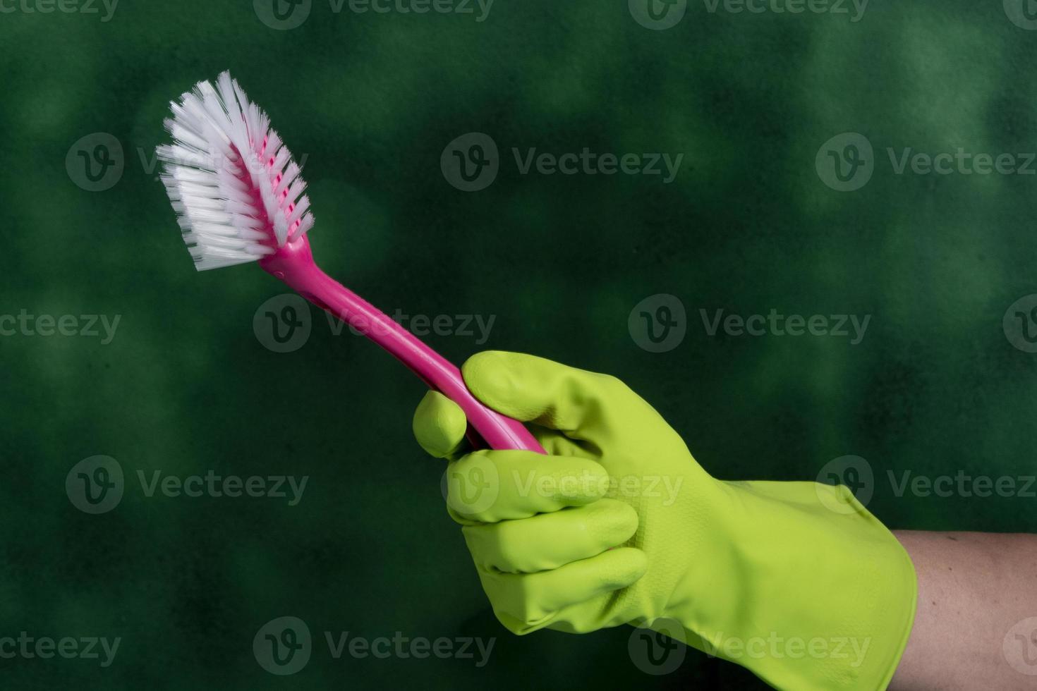 hand with protective glove holding packaging of cleaning products used for home hygiene photo