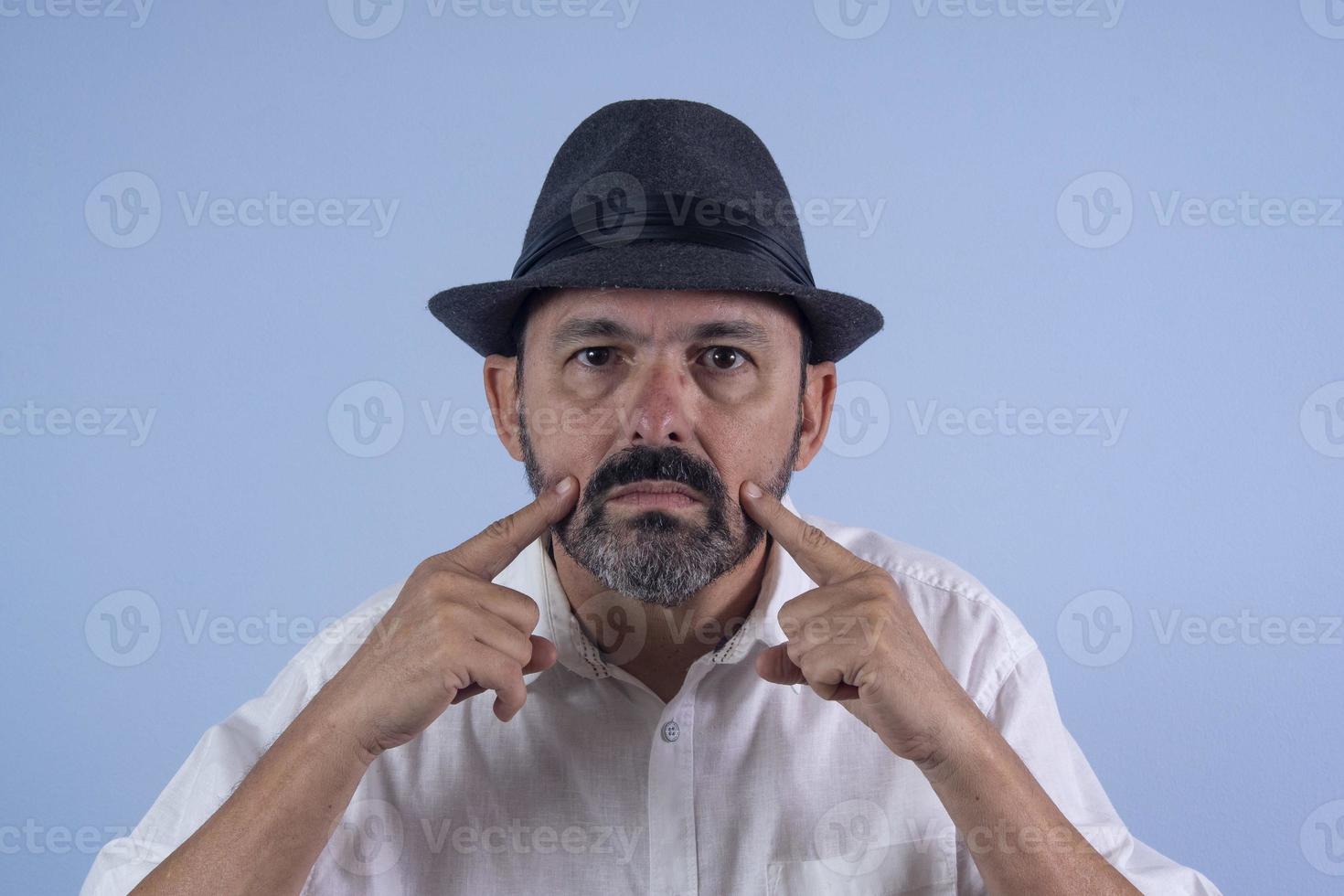 retrato de un hombre barbudo de 60 años con fondo azul foto