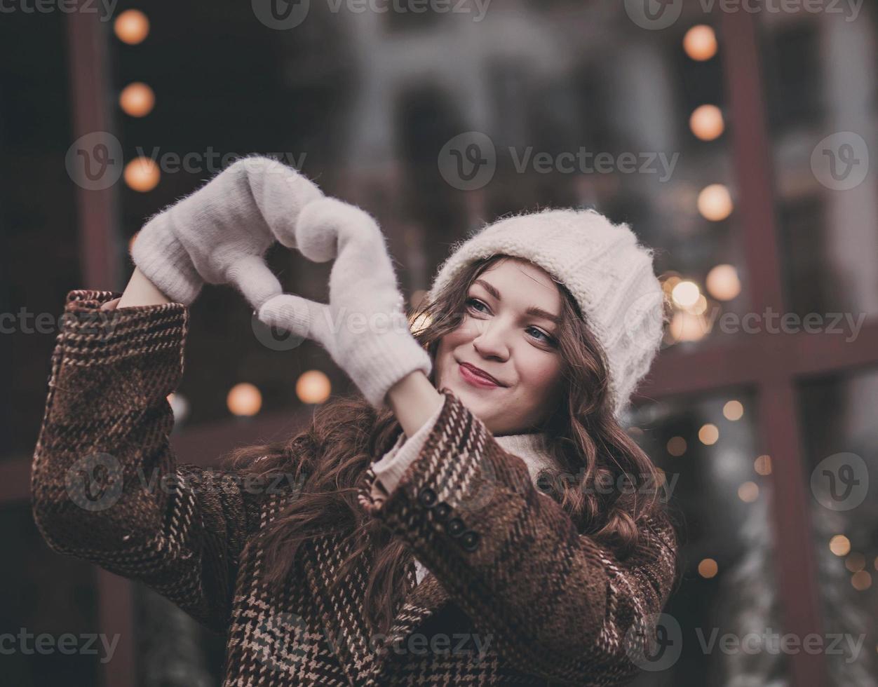 woman in mittens shows heart shape photo