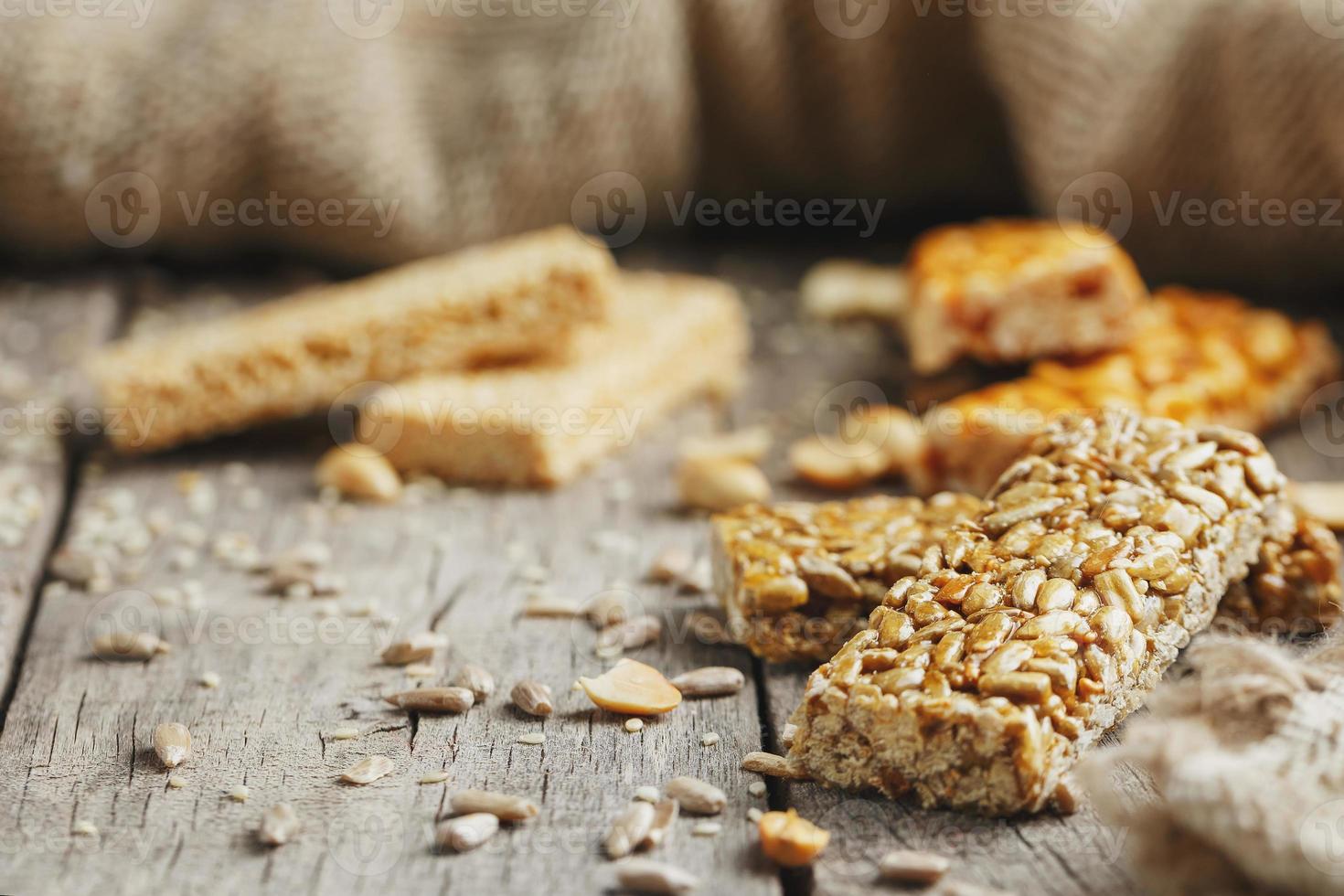 Sweets Bar of sunflower seeds on a vintage background with burlap. Delicious oriental sweets Gozinaki from sunflower seeds, sesame and peanuts, covered with honey with a shiny icing photo