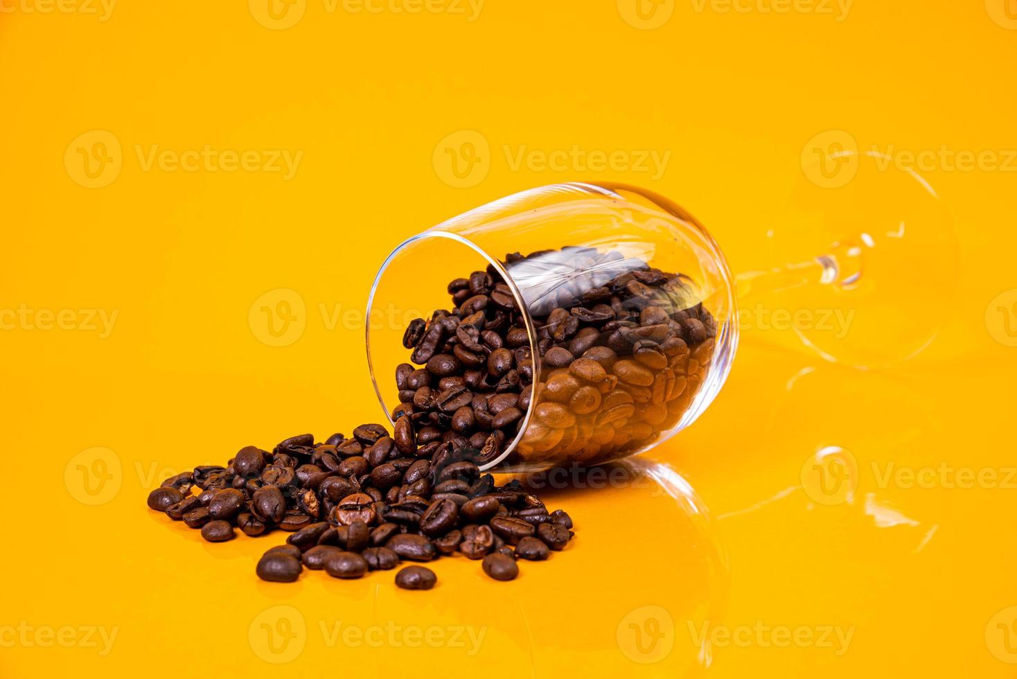 Dropped Many roasted coffee beans in a glass, in bucket jar. self-tapping screw for metal, for iron, chrome-plated self-tapping screw, orange yellow background photo