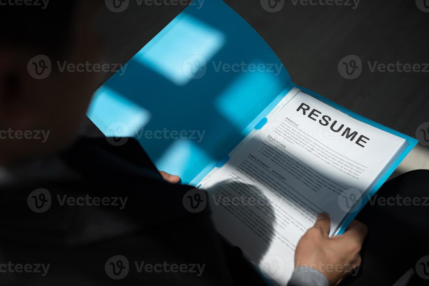 Unemployed man apply for a job sitting in queue holding resume