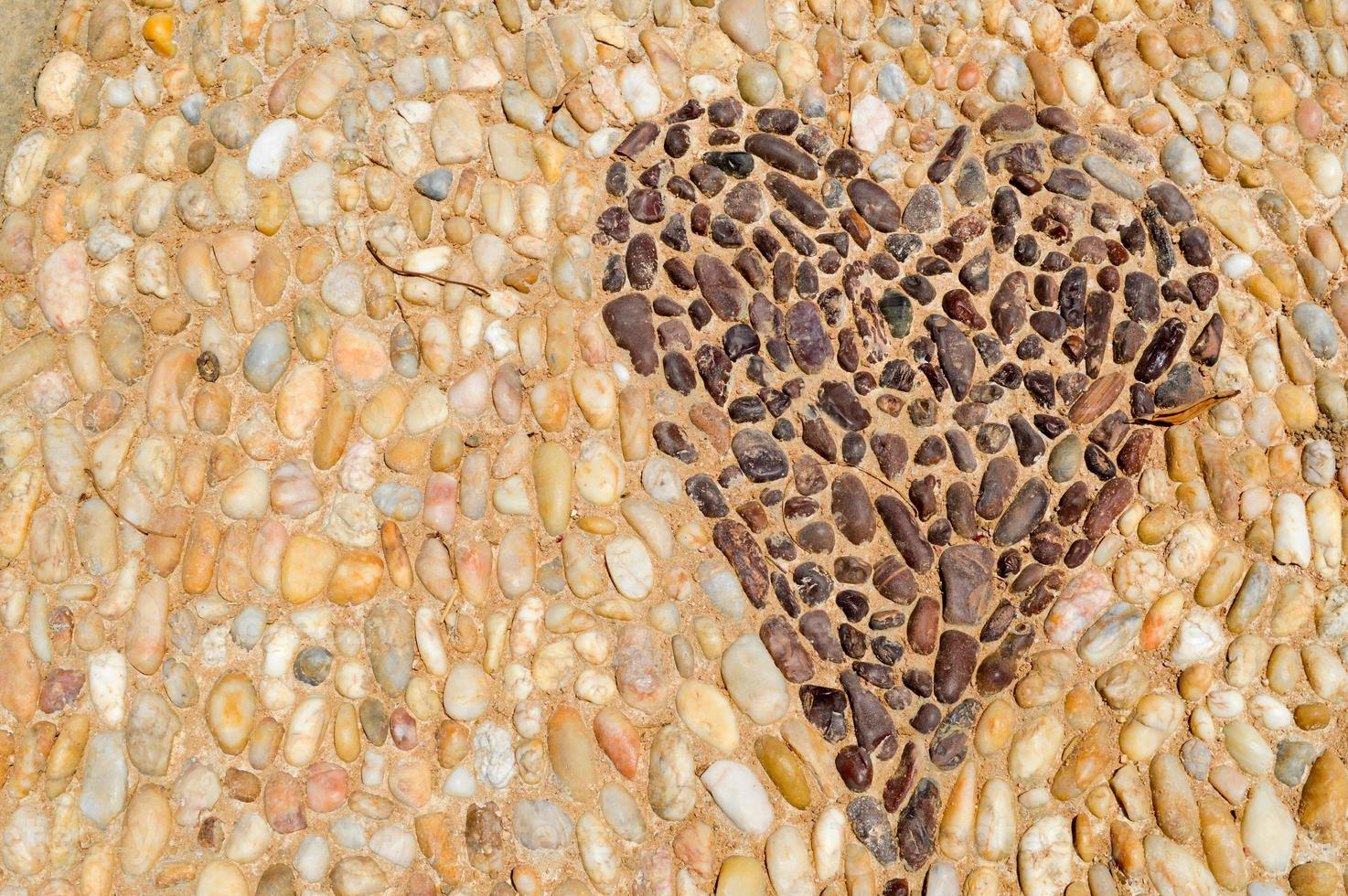 The texture of the stone wall, the road from small round and oval stones with abstracted lines of heart patterns sandy seams of natural old yellow black brown. The background photo