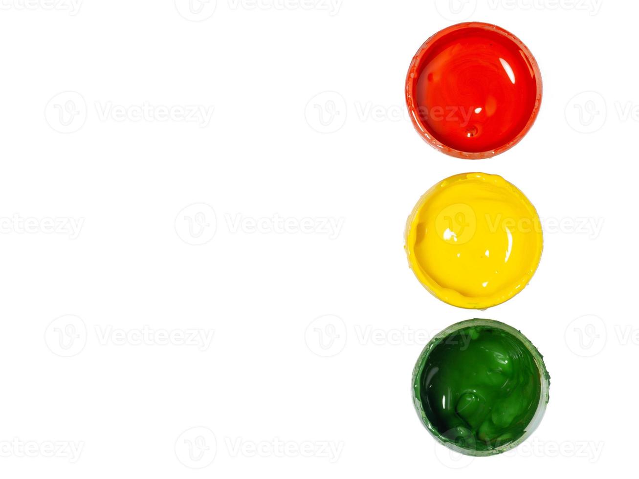Jars with yellow, green and red paint on a white background. Banks of gouache. Bright background. Traffic lights.  Artist's workshop. photo