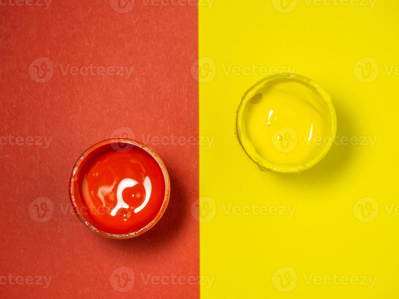 Jars with yellow and red paint on a yellow and red background. Bank of gouache. Bright background.  Artist's workshop. photo