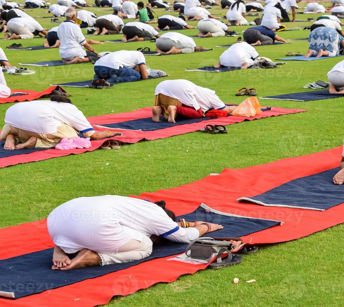 Group Yoga exercise session for people of different age groups at cricket stadium in Delhi on International Yoga Day, Big group of adults attending yoga session photo