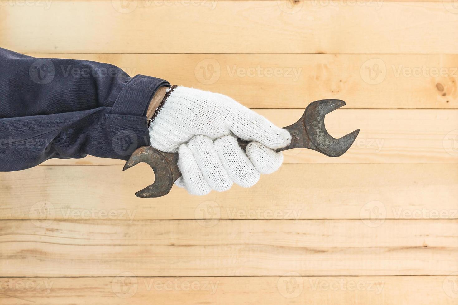 Hand in glove holding spanner photo