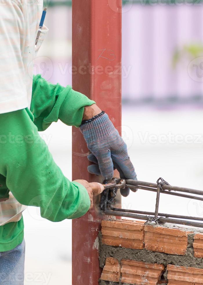 trabajadores que utilizan alambre de acero y barras de refuerzo antes de verter el hormigón foto