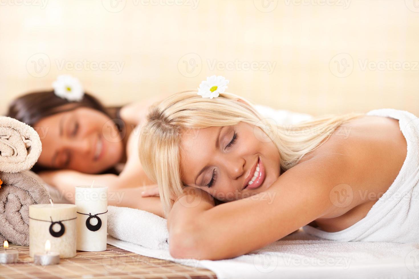 Two young women relaxing at the spa center photo