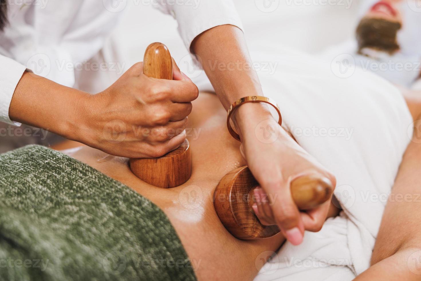 masaje de maderoterapia con copa de madera en un centro de spa foto