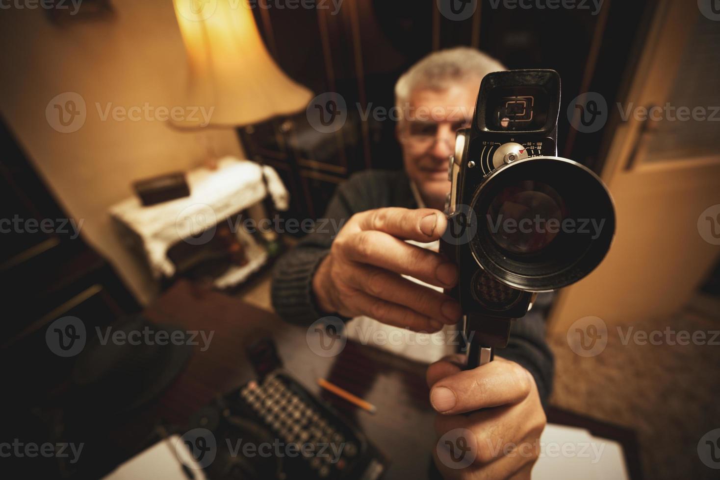 hombre mayor que sostiene la cámara de video foto