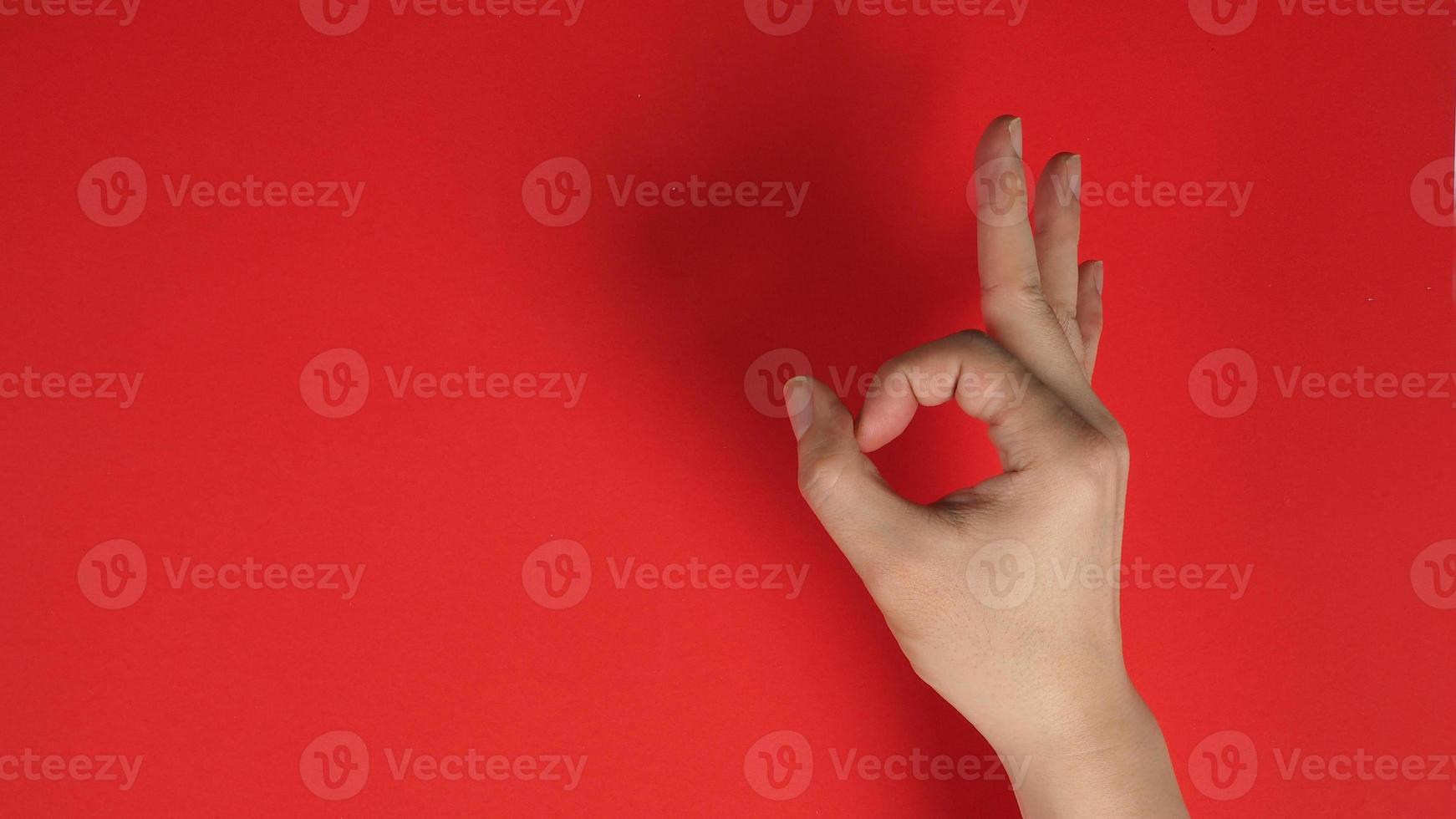 The A-Ok Hand Sign with right hand on red background. photo