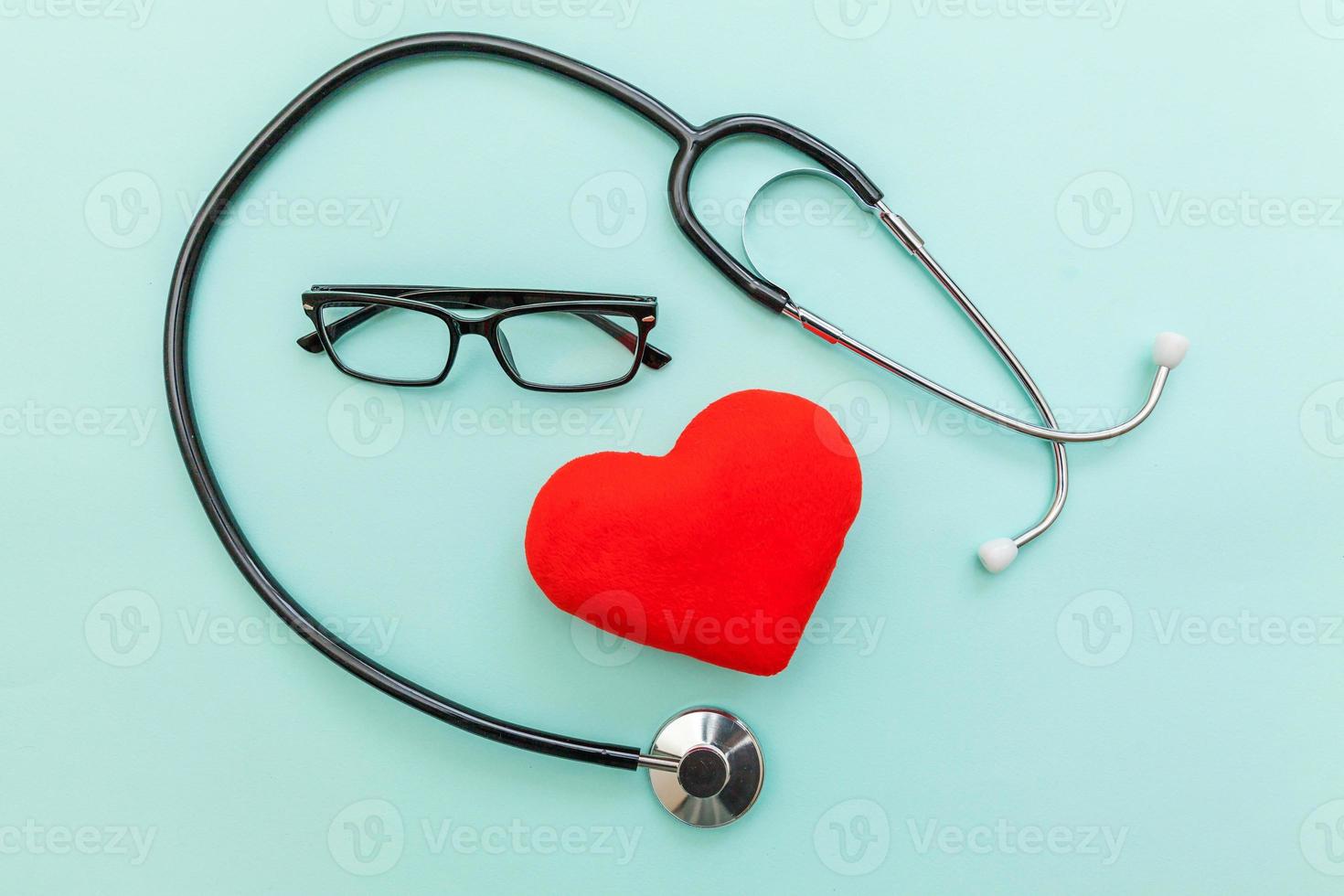 Medicine equipment stethoscope or phonendoscope glasses and red heart isolated on trendy pastel blue background. Instrument device for doctor. Health care life insurance concept photo