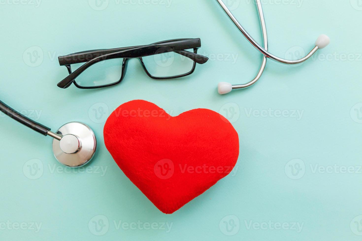 Medicine equipment stethoscope or phonendoscope glasses and red heart isolated on trendy pastel blue background. Instrument device for doctor. Health care life insurance concept photo