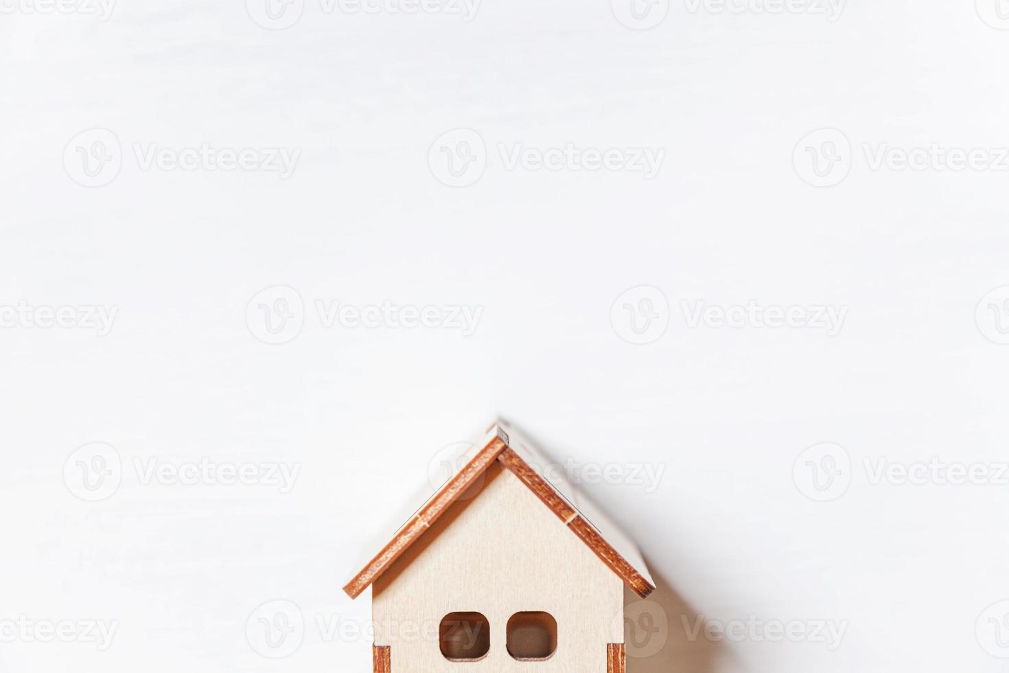 Simply minimal design with miniature toy house isolated on white background. Mortgage property insurance dream home concept. Flat lay top view, copy space photo