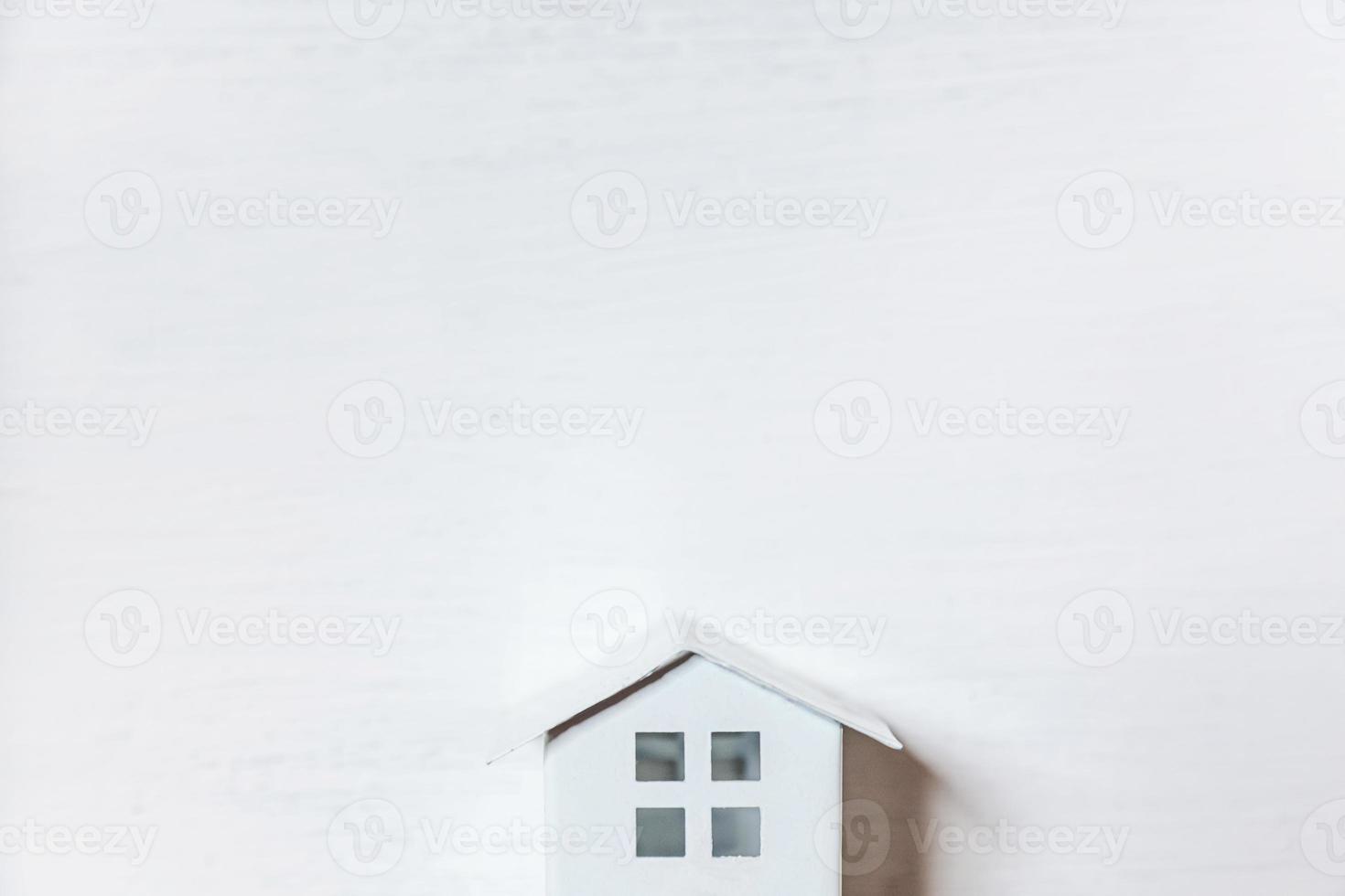 Simply minimal design with miniature toy house isolated on white background. Mortgage property insurance dream home concept. Flat lay top view, copy space photo