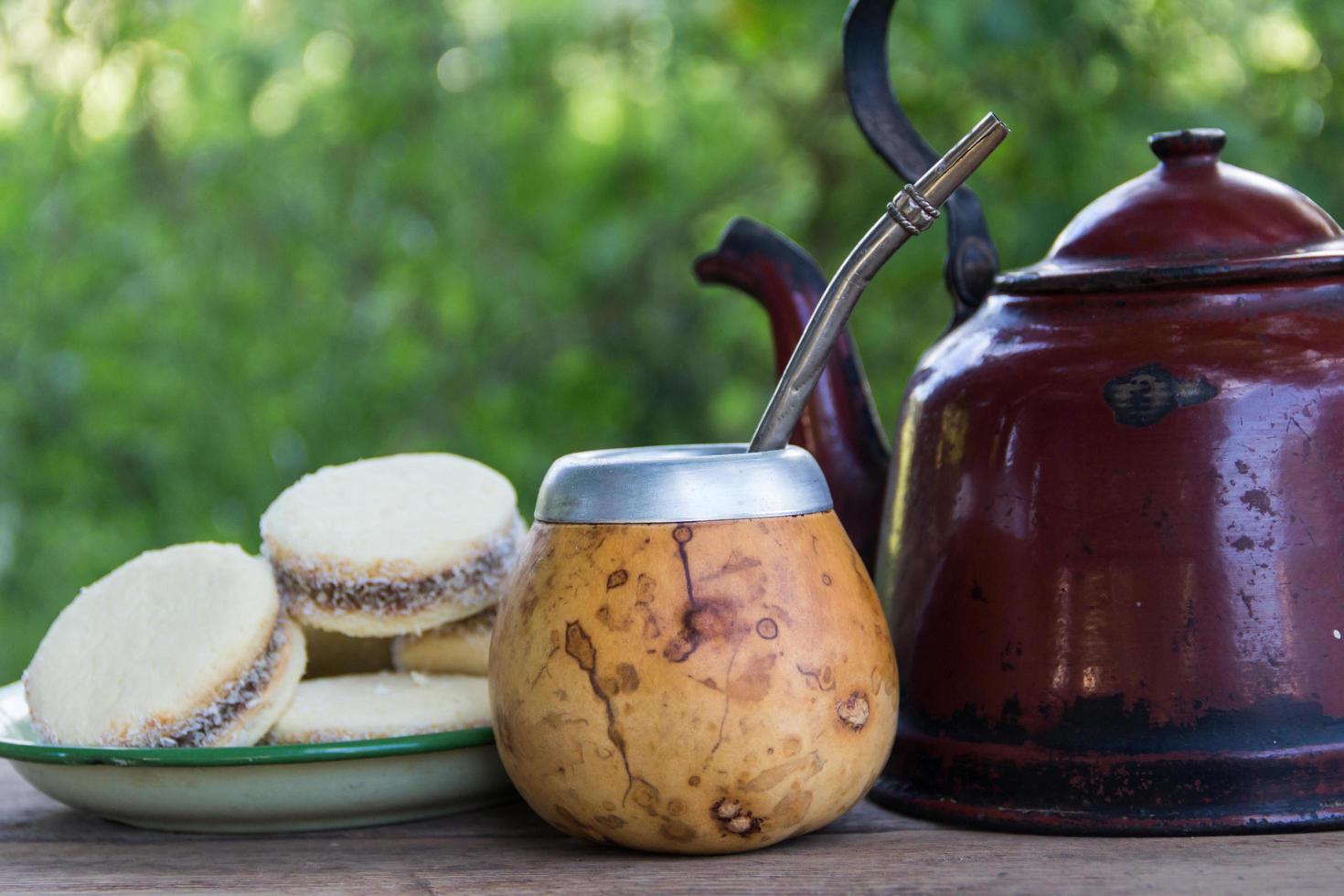Mate and kettle with a plate of alfajores and yerba mate infusion in the Argentine countryside photo