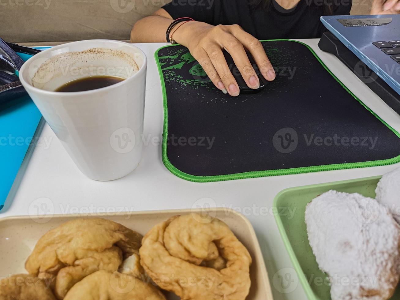 una joven bebió un vaso de café acompañado de bocadillos durante los descansos durante el tiempo de trabajo. foto