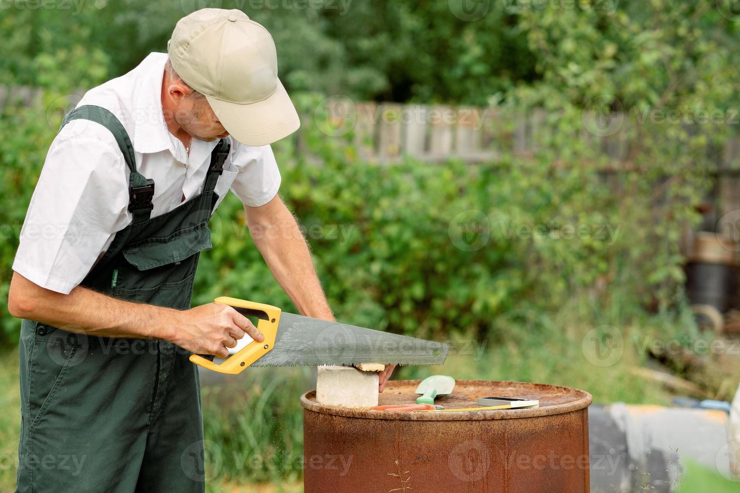 Carpenter using a wood saw to cut wood sheets. A carpenter with a hand