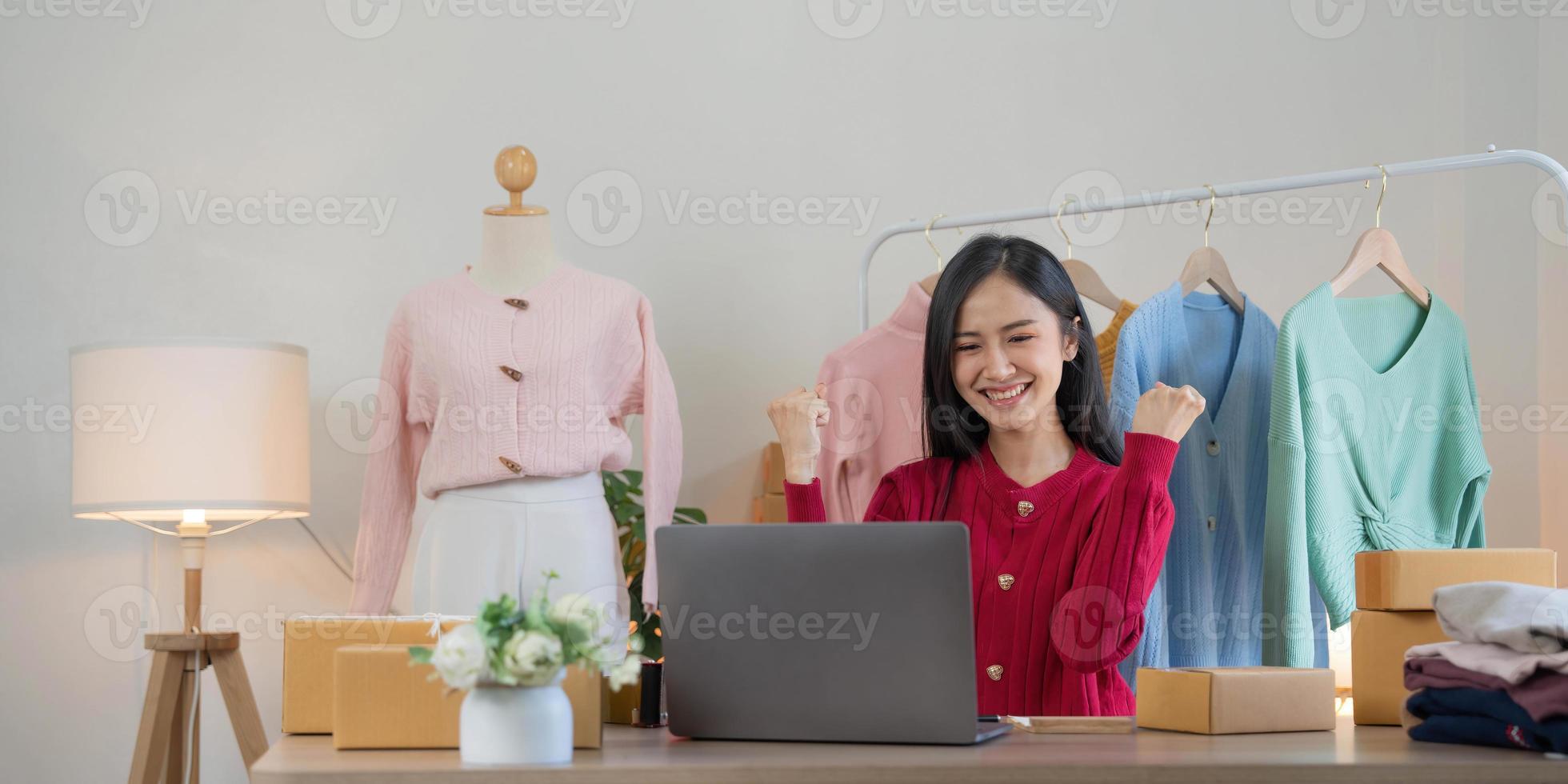 Asian SME business women use laptop computer checking customer order online shipping boxes at home. Starting Small business entrepreneur SME freelance. Online business, Work at home concept. photo