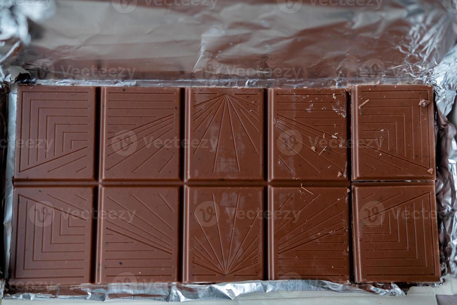 open bar of milk chocolate . chocolate bar in foil photo