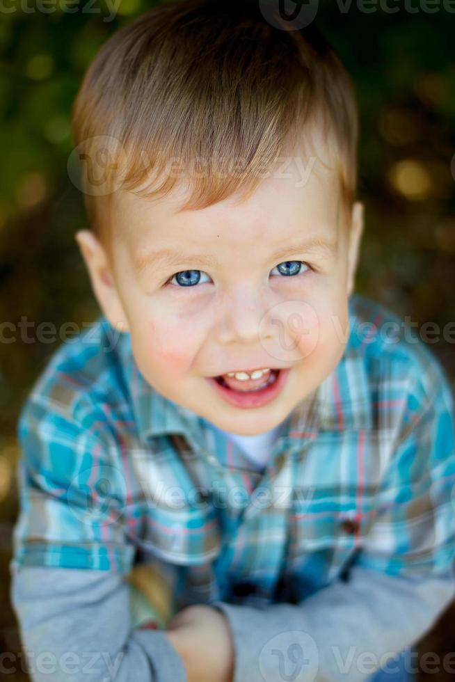 dulce bebé, primer plano retrato de niño aislado sobre fondo de madera, lindo niño pequeño con ojos azules foto