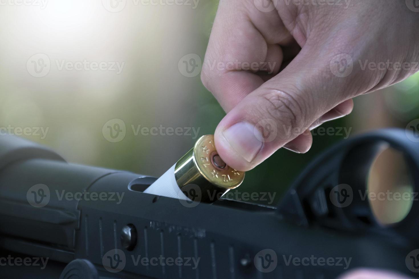 shotgun shooter is changing and inserting new bullet into shotgun, soft and selective focus. photo