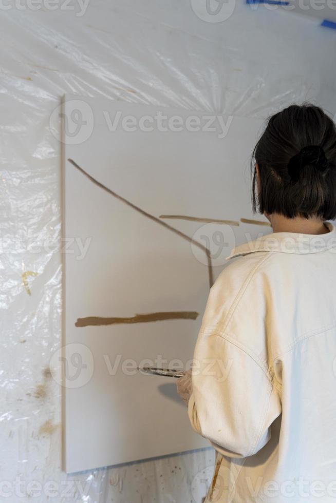 young latin woman, in her own painting studio, creates paintings different artistic techniques photo