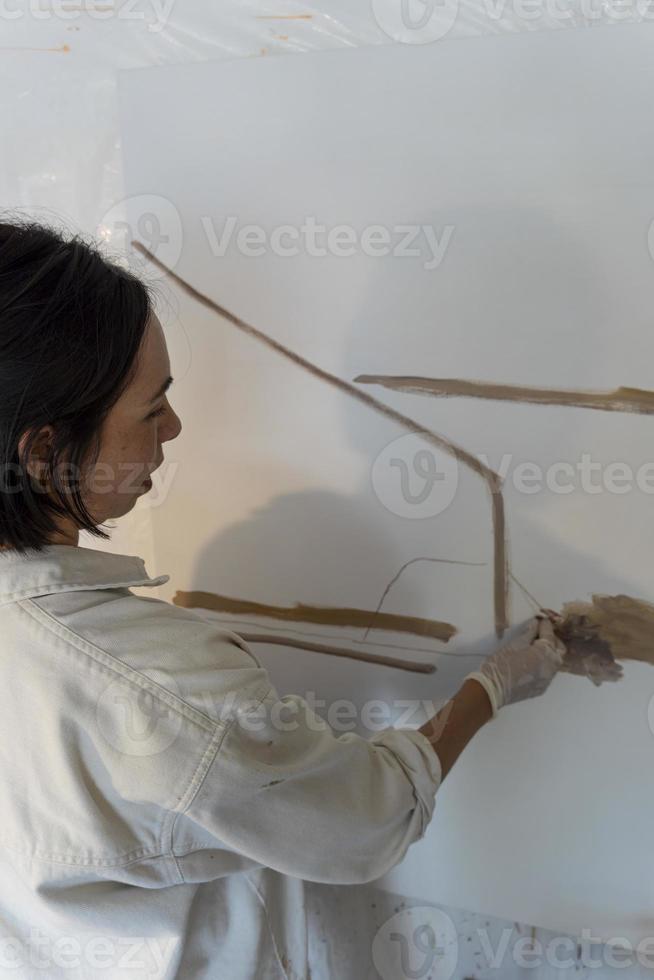 young latin woman, in her own painting studio, creates paintings different artistic techniques photo