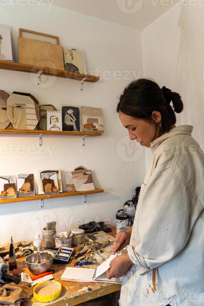 art workshop, messy objects, brushes, paint all mixed up disorganized, woman artist photo